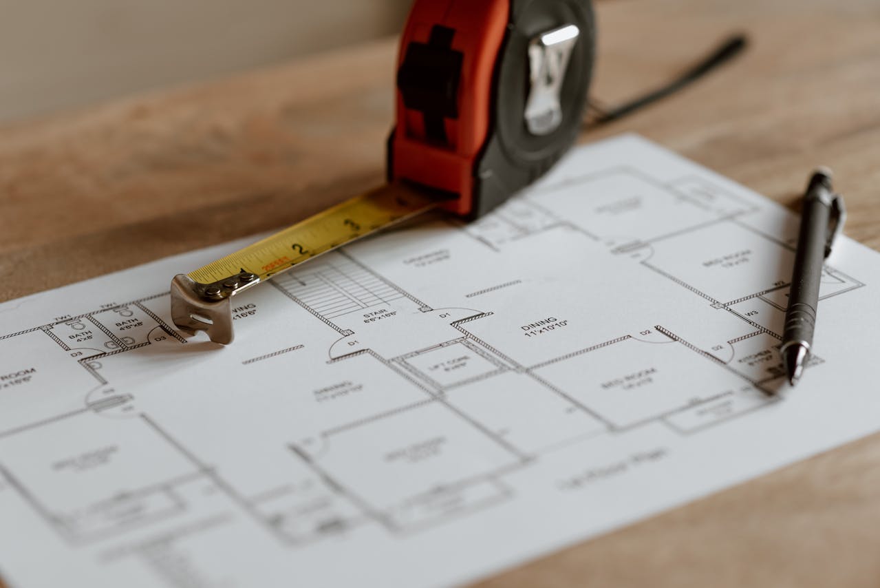 tape measure sitting atop a house blueprint